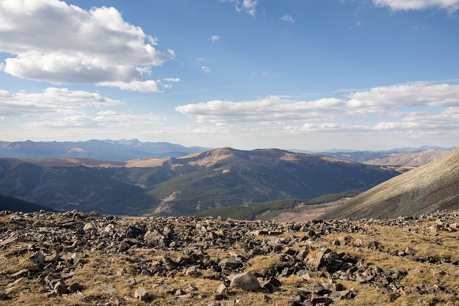 Rocky tundra and layered mountain ridges under big clouds, seen from Mosquito Pass