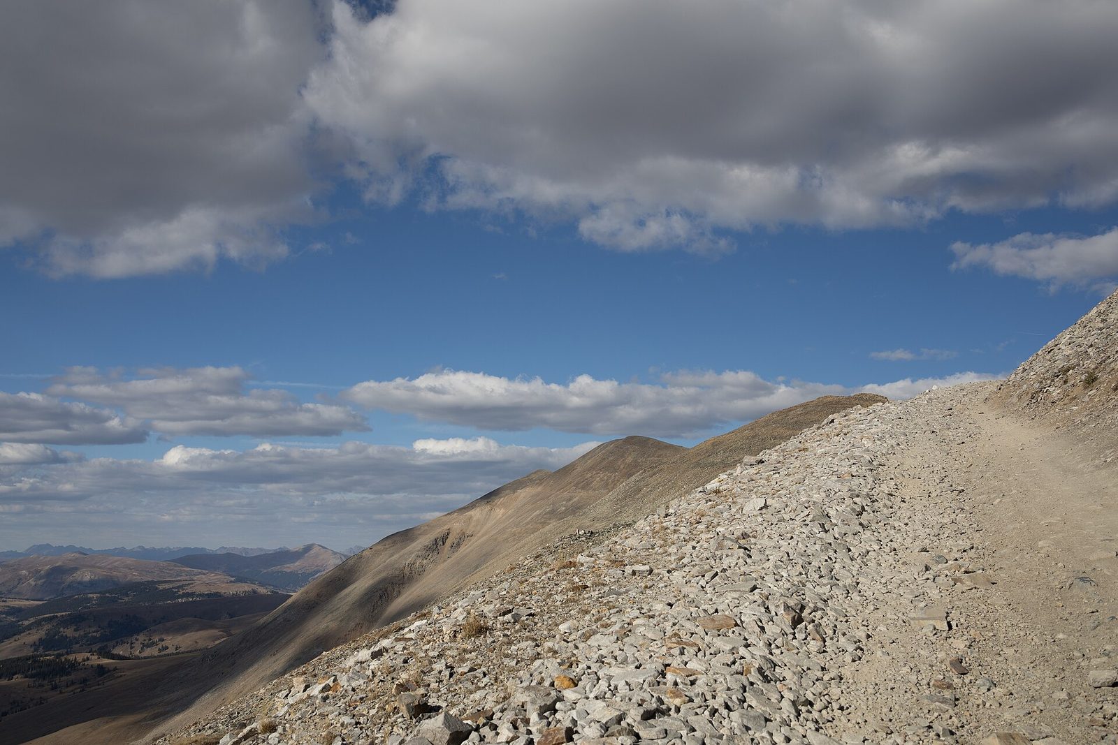 A rocky road climbing a barren ridge above treeline toward Mosquito Pass