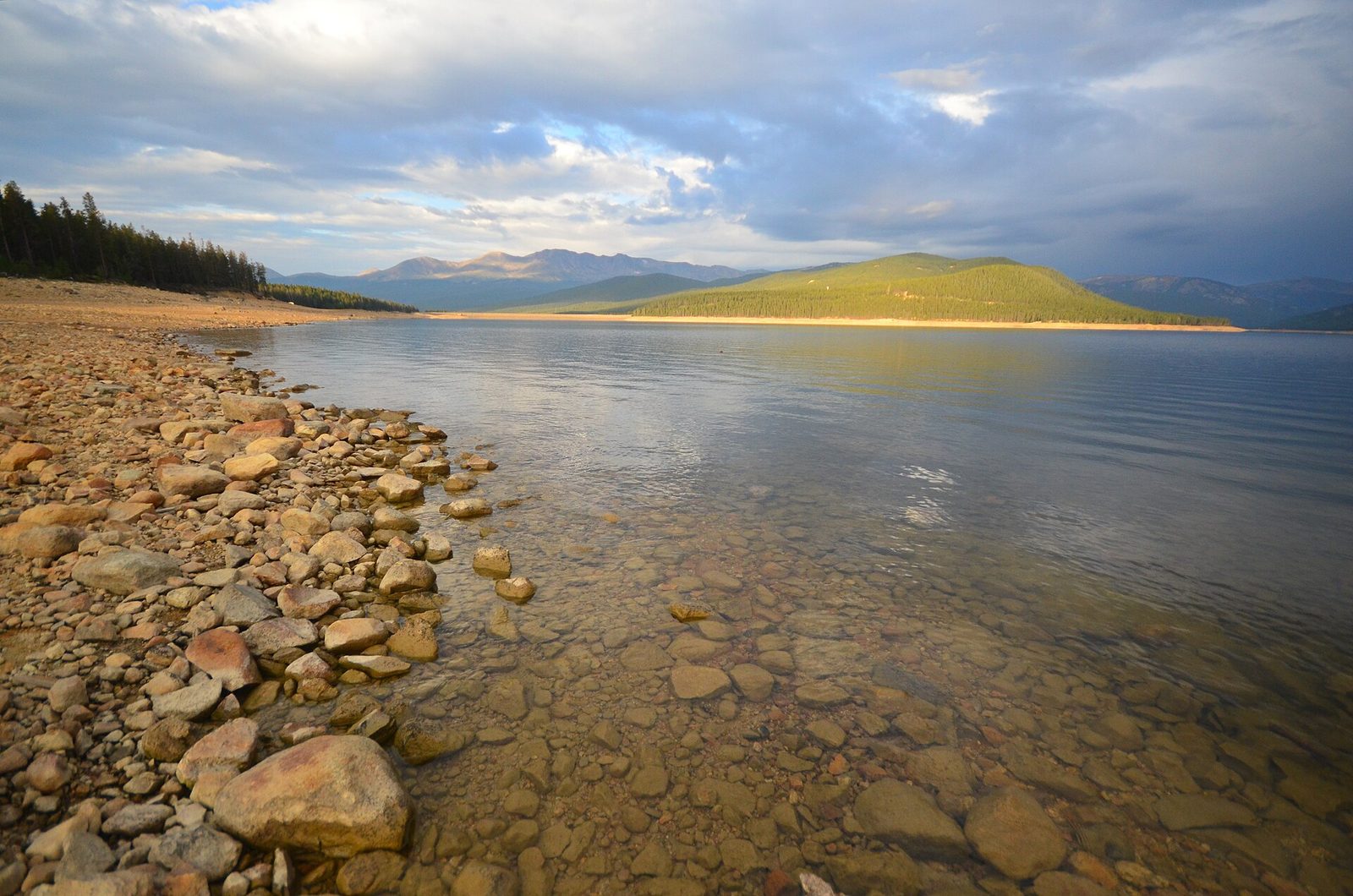 Rocky shoreline and calm water at Turquoise Lake at sunrise